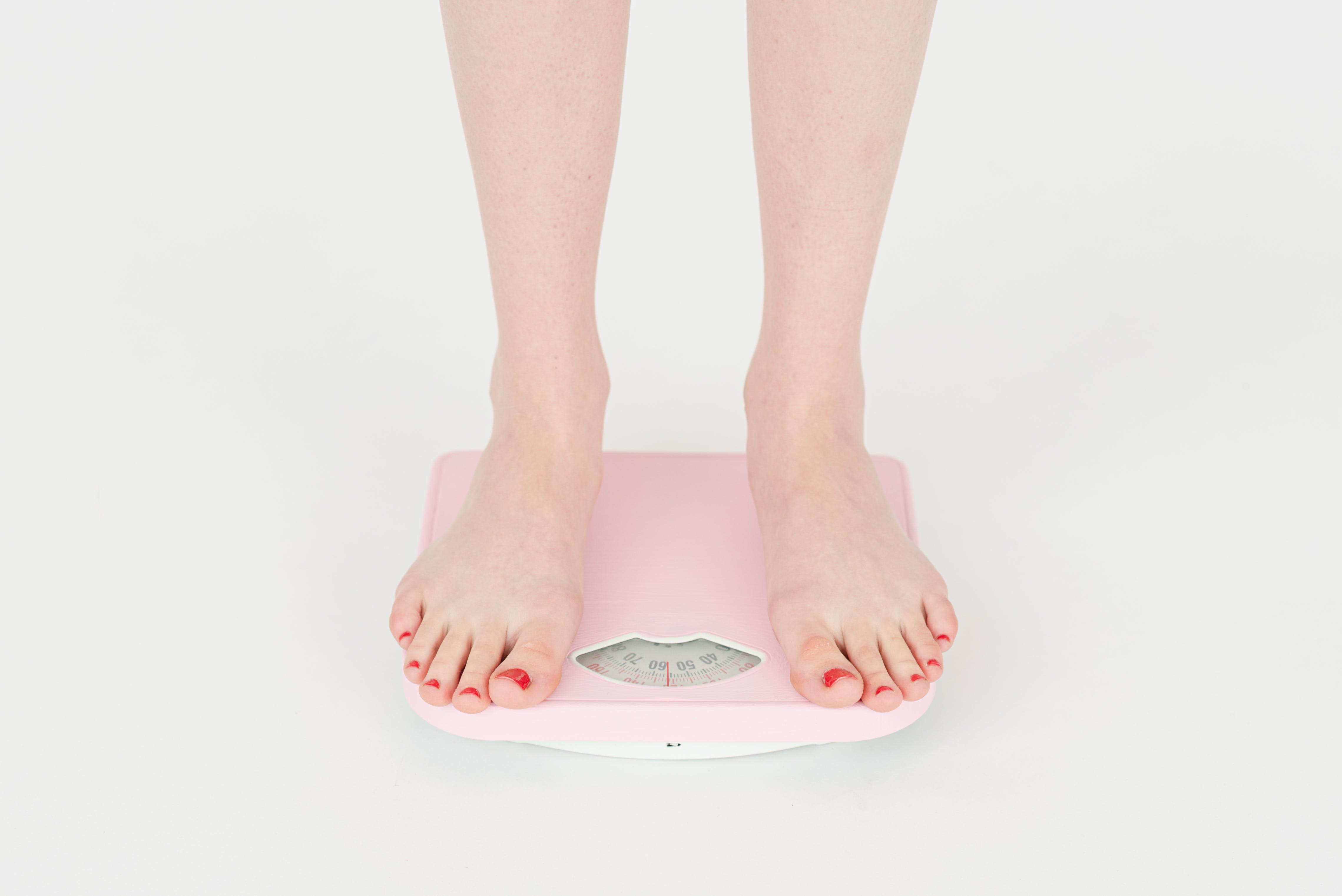 A person standing on a scale weighing themselves as different sized people will fit into different sized cadaver bag.