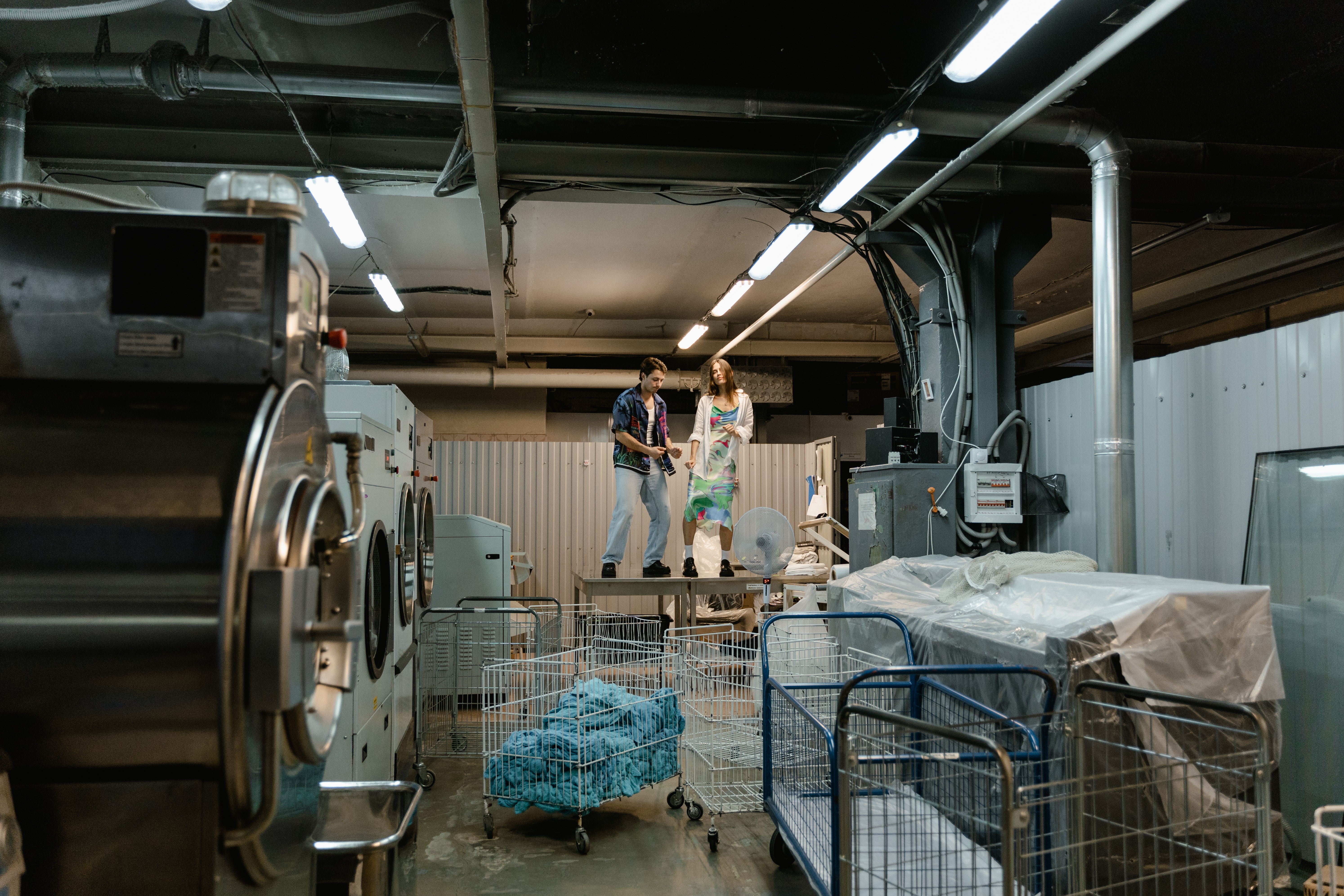 A man and a woman in a laundry room to show whether traditional or soluble laundry bags are best for hospitals 